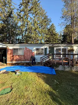Old siding removed exposing insulation on a single-story home
