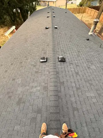 New charcoal shingle roof on a long ranch home