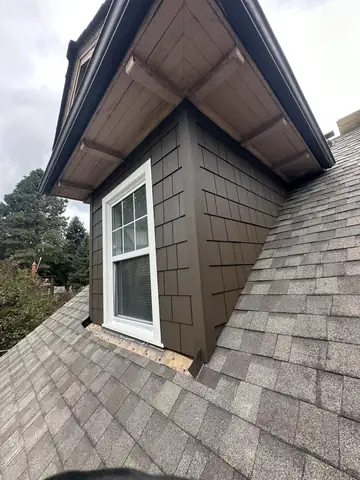 New shingle roof around a dormer with fresh siding