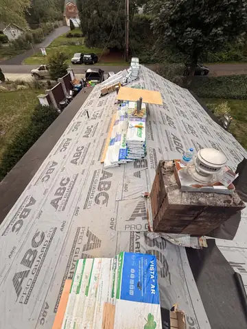 Underlayment laid with shingle bundles by the chimney